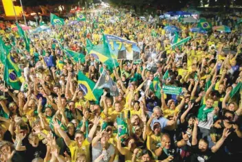  ?? — AFP ?? Supporters of Jair Bolsonaro celebrate in front of the National Congress in Brasilia, after he won the presidenti­al election.