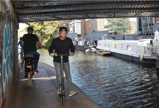  ??  ?? SILENT MENACE: Cyclists and an electric scooter rider vie for space under the bridge beside Regent’s Canal where the young woman was knocked off