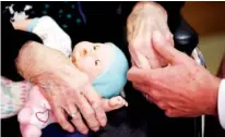  ?? ASSOCIATED PRESS FILE PHOTO ?? A son, at right, holds his mother's hand in April 2016 as they talk at her nursing home in Adrian, Mich.