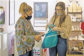  ?? STAFF PHOTOS BY C. B. SCHMELTER ?? Melissa Tawzer, left, and Ansley Osborne discuss an order at Owl Cove on Nov. 11 in Ooltewah.