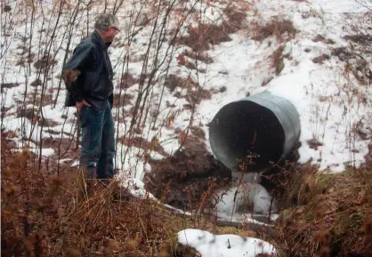  ?? Photograph: Steven M Herppich/AFP/Getty Images ?? David Huff, chair of the zoning and planning commission for Osceola township, stands before the local Chippewa Creek last year.