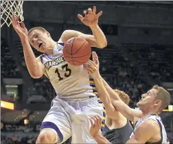  ?? ASSOCIATED PRESS ?? Marquette’s Henry Ellenson (left) and Luke Fischer battle for the ball Saturday against Creighton center Geoffrey Groselle during the second half.