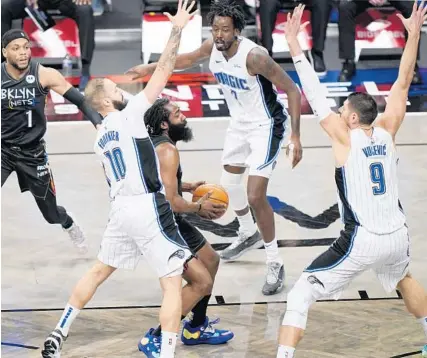  ?? KATHY WILLENS/AP ?? Magic guard Evan Fournier (10), forward Al-Farouq Aminu (2) and center Nikola Vucevic triple-team Nets guard James Harden as Nets guard Bruce Brown watches the play Thursday night in New York.