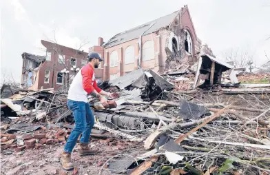  ?? MARK HUMPHREY/AP ?? The Christmas Day bombing in downtown Nashville, Tennessee, was the latest tragedy to befall Music City in 2020. Above, Sumant Joshi helps clean up rubble at a church damaged by storms that spawned deadly tornadoes in March.
