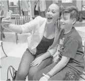  ??  ?? Daniella Rodriguez, Correa’s fiancée, takes a photo with Byron Ramirez, 12, as she and Correa visited patients on Tuesday.