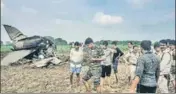  ?? PTI ?? ■ Policemen and locals gather at the site where MiG-21 trainer jet crashed near the Gwalior airbase on Wednesday.