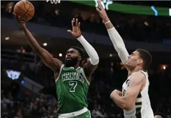  ?? Ap pHOTOS ?? DIALED IN: Jaylen Brown drives past Milwaukee’s Brook Lopez during the second half of last night’s game. Brown had his second triple-double of the season with 22 points, 11 assists and 10 rebounds in a 127-121 loss.
