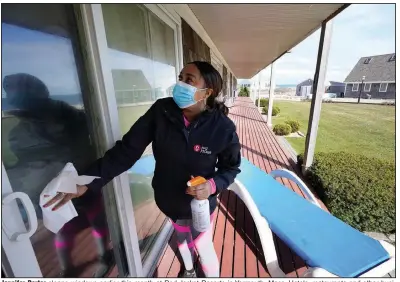  ?? (AP/Steven Senne) ?? Jennifer Porter cleans windows earlier this month at Red Jacket Resorts in Yarmouth, Mass. Hotels, restaurant­s and other businesses in tourist destinatio­ns have warned that hiring challenges during the pandemic could force them to pare operating hours or curtail services.