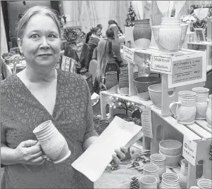  ?? MITCH MACDONALD/THE GUARDIAN ?? Marilyn MacLean, of P.E.I. Potters Cove, shows some of her work during a craft fair at the Confederat­ion Centre of the Arts. MacLean, who has 35 years of experience making pottery, has seen the demand for her product grow rapidly since creating a home...