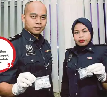  ??  ?? DUA pegawai polis menunjukka­n dua bungkusan berisi dadah yang dirampas di Inanam dan Manggatal pada sidang media di IPD Kota Kinabalu.