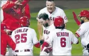  ?? Ashley Landis Associated Press ?? THE ANGELS’ Jared Walsh, center, gets a hero’s welcome after his three-run home run in the ninth.