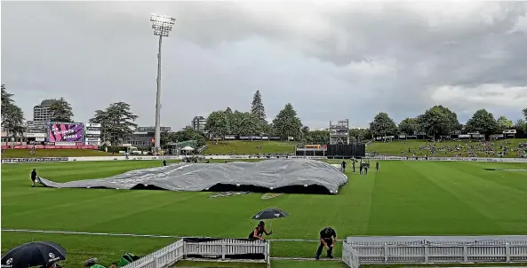  ?? PHOTOSPORT ?? Ground staff bring out the covers at Seddon Park in Hamilton on Wednesday night.