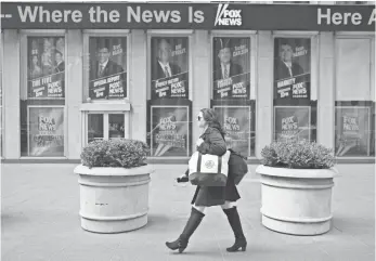  ??  ?? MARY ALTAFFER, AP A woman walks past the News Corp. headquarte­rs in New York City in April.