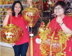  ??  ?? Festive decor: Leong (right) and colleague Effie Chew Shi Wei showing some of the popular lanterns this year.