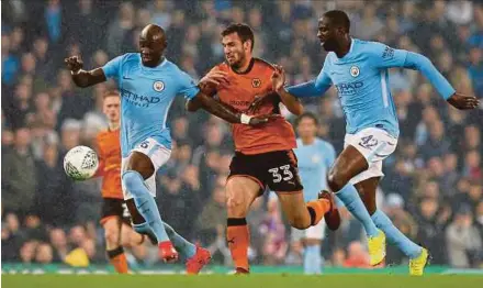  ?? REUTERS PIC ?? Manchester City’s Yaya Toure (right) and Eliaquim Mangala tussle for the ball with Wolverhamp­ton Wanderers’ Leo Bonatini in their League Cup match on Tuesday.