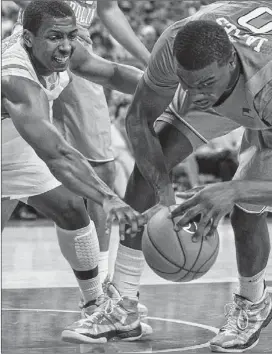  ??  ?? Texas’ Jonathan Holmes (left) and North Carolina’s Joel James battle for a rebound during the first half of their game on Tuesday.