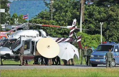  ?? ATHIT PERAWONGME­THA / REUTERS ?? One of the rescued boys is moved under large umbrellas from a Royal Thai Police helicopter to a waiting ambulance at a military airport in Chiang Rai, northern Thailand, on Monday.