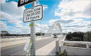  ?? JULIE JOCSAK THE ST. CATHARINES STANDARD ?? Crisis line signs have been posted at each end of the Burgoyne Bridge following recent suicides on the bridge.