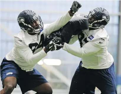  ??  ?? Defensive tackle Malik McDowell, left, was the Seahawks’ top draft pick and was already learning to play a new position Saturday at the team’s rookie mini-camp in Renton, Wash.