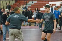  ?? OWEN MCCUE - MEDIANEWS GROUP ?? Pottsgrove’s Stephen Hennelly, right, receives the Most Outstandin­g Wrestler trophy from Pottsgrove AD Steve Anspach following Wednesday’s Border Battle with Pottstown.