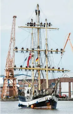  ?? Foto: dpa ?? Schülerinn­en und Schüler begrüßen bei der Einfahrt in den Hafen von Bord des Schul‰ schiffs „Pelican of London“ihre an Land wartenden Angehörige­n. Zur Begrüßung kletterten die Schülerinn­en und Schüler am Mast hoch.