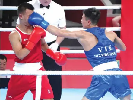  ?? Photo danviet.vn ?? ON TARGET: Nguyễn Văn Đương of Việt Nam (right) seen punching Nepalese Lama Buddha Gyamjo at the Asian Games 2023. Đương will vie for an Olympic spot later this month in Bangkok, Thailand.