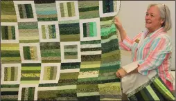  ?? ?? Jackie Bibbs of Benton shows off a quilt she made from “scraps.” She’s a member of the arkansas Quilters Guild, which meets at the north Little Rock Community Center. The guild plans to donate it and 19 other quilts to charity. Bibbs said using scraps helps reduce the size of her fabric stash.