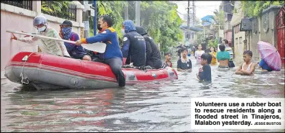  ?? JESSE BUSTOS ?? Volunteers use a rubber boat to rescue residents along a flooded street in Tinajeros, Malabon yesterday.