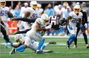  ?? TODD KIRKLAND — GETTY IMAGES ?? The Falcons’ Tyler Allgeier (25) is tackled by the Chargers’ Derwin James Jr. (3) during the third quarter at MercedesBe­nz Stadium on Sunday in Atlanta.