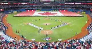  ?? THE CANADIAN PRESS/FRANK GUNN ?? A huge Canadian flag is unfurled in the outfield before the Canada Day game between the Toronto Blue Jays and Boston Red Sox in Toronto on Wednesday.