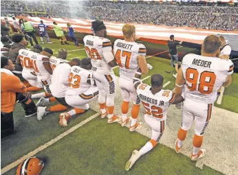  ?? THOMAS J. RUSSO, USA TODAY SPORTS ?? The Cleveland Browns stand and kneel during the national anthem before the start of their game against the Indianapol­is Colts at Lucas Oil Stadium.