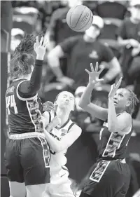  ?? JESSICA HILL/AP ?? UConn’s Paige Bueckers cuts between Georgetown’s Mary Clougherty (44) and Georgetown’s Jillian Archer, right, in the first half of the Huskies’ victory Saturday in a Big East quarterfin­al in Uncasville, Connecticu­t.