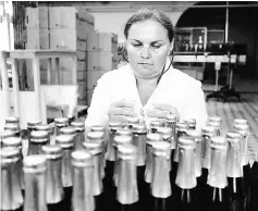  ??  ?? Photos above and below show employees check bottles as they work on the production line in the ‘Artwinery’ winery firm in the eastern Ukrainian city of Bakhmut on July 12.