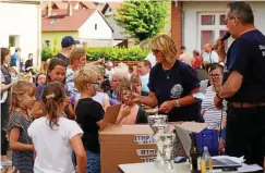  ?? FOTO: ACHIM SCHULZ ?? Heike Huhnstock und Jürgen Übensee vom Dorfclub Bothenheil­ingen bei der Ausgabe der vielen kleinen Preise für die Teilnehmer am Kisten- und Kettcar-rennen.