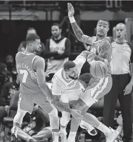  ?? Kevin C. Cox / Getty Images ?? Rockets guard D.J. Augustin, center, draws a foul while splitting the defense of the Hawks’ Timothe Luwawu-Cabarrot (7) and John Collins in Monday’s game.