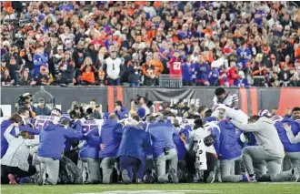  ?? AP PHOTO/JOSHUA A. BICKEL ?? Buffalo Bills players and staff pray for Buffalo Bills’ Damar Hamlin during the first half of Monday’s game against the Cincinnati Bengals in Cincinnati.