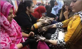  ?? FAREED KHAN — THE ASSOCIATED PRESS ?? Pakistani beautician­s paint hands of customers with traditiona­l henna in preparatio­n for the upcoming Eid al-Fitr holidays, that marks the end of the holy fasting month of Ramadan, at a beauty saloon in Karachi, Pakistan, Monday.