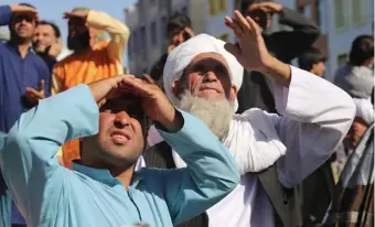  ?? Ap ?? ON DISPLAY: People look up at a dead body hanged by the Taliban from a crane in the main square of Herat city in western Afghanista­n on Saturday.