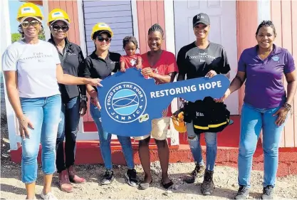  ?? CONTRIBUTE­D ?? Suzette Wilson (third right), one of three house recipients for Mother’s Day from BossMom Network, receives her new house (from left) Diahann Gordon Harrison, Jamaica’s children’s advocate; Karen Phillips, director on the board, FirstRock Foundation; Santanio Husi, operations officer, FirstRock Foundation; Michelle Gordon, founder, BossMom Network; and Marsha Burrell Rose, developmen­t and marketing manager, Food For The Poor Jamaica in Curatoe Hill in Clarendon on Tuesday.
