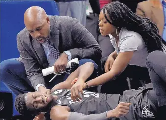  ?? HANNAH FOSLIEN/ASSOCIATED PRESS ?? Brooklyn Nets guard Caris LeVert receives medical attention after suffering a foot injury against the Minnesota Timberwolv­es on Monday night.