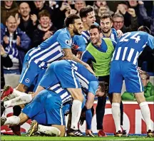  ??  ?? LOTS TO CELEBRATE: Brighton’s players pile on to Pascal Gross after his shot clinched three points against Watford