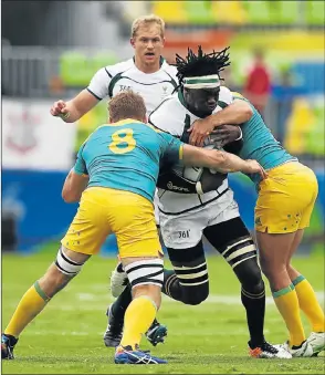  ?? Picture: GETTY IMAGES ?? TOUGH TACKLE: South Africa’s Tim Agaba is caught by Australia’s Pat McCutcheon, left, and James Stannard during their sevens Pool B match yesterday