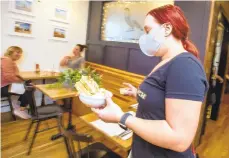  ?? S APRILGAMIZ/THE MORNING CALL ?? Wearing a mask Emma Shiner, a bartender delivers a tasty dessert of ice cream and waffles to a table. Union and Finch in Allentown is one of the restaurant­s in the Lehigh Valley being praised for doing things right during the Covid-19 pandemic.