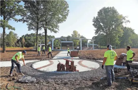  ?? KYLE ROBERTSON/COLUMBUS DISPATCH ?? Members of the landscapin­g company Yard Solutions put the final touches on the new field Friday for Miracle League of New Albany. A grand opening for the event is scheduled for Oct. 2 and will feature at least two baseball games.