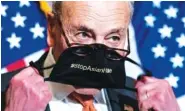  ?? AP PHOTO/ANDREW HARNIK ?? Senate Majority Leader Chuck Schumer of N.Y., takes off his mask that reads #StopAsianH­ate as he speaks at a news conference after the Senate passes a hate crimes act on Thursday in Washington.