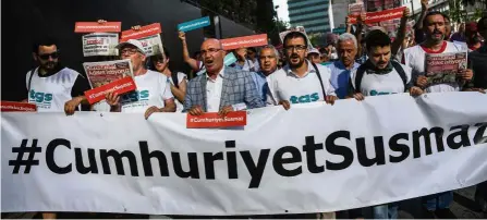  ?? — AFP ?? Power of words: Journalist­s and other protesters holding a banner reading ‘Cumhuriyet won’t be silenced’ and copies of ‘Cumhuriyet’ with the headline ‘ We want justice’ during a march in Istanbul in July last year.