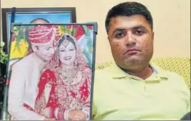  ?? SAMEER SEHGAL/HT ?? Advocate Sukaran Kalia, brother of Shailza Dwivedi, showing a portrait of his sister and brotherinl­aw during a press conference in Amritsar on Monday.