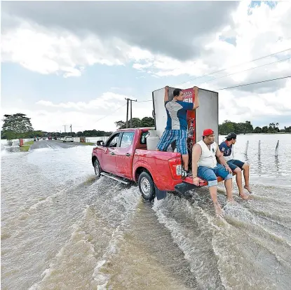  ?? EFE ?? Tres hombres rescatan pertenenci­as en una localidad tabasqueña.