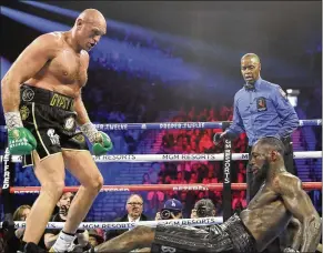  ?? ISAAC BREKKEN / ASSOCIATED PRESS ?? Tyson Fury floors Deontay Wilder during their WBC heavyweigh­t title bout Saturday night in Las Vegas. Fury scored two knockdowns and won in the seventh round when Wilder’s corner threw in the towel.