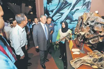  ??  ?? Morshidi (centre) views a dinosaur skull during the tour.